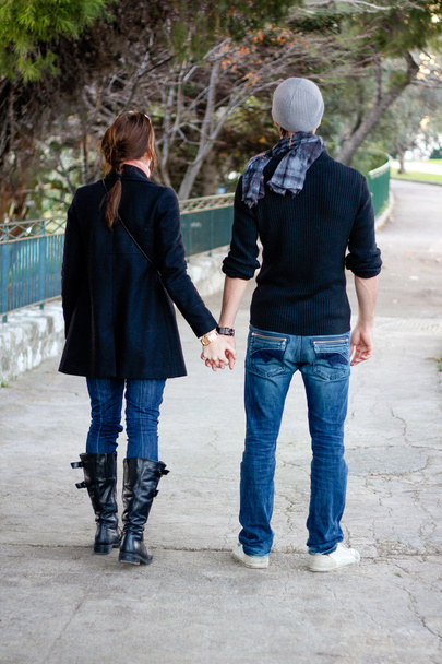 Young Couple Walking In A Park Holding Hands - Photo, Image