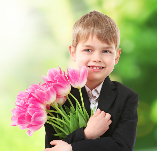 Cute boy with flowers on blurred background - Zdjęcie, obraz