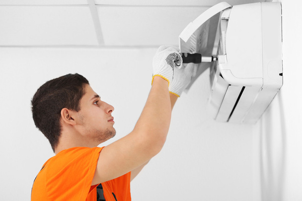 Technician repairing air conditioner - Fotoğraf, Görsel