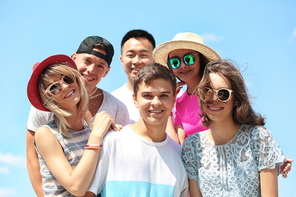 Happy teenagers on blue sky background - Fotó, kép