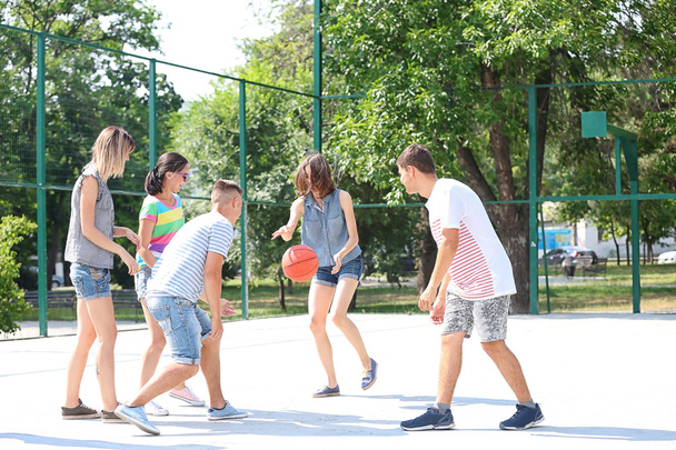 Teenagers playing basketball outdoors - Fotó, kép