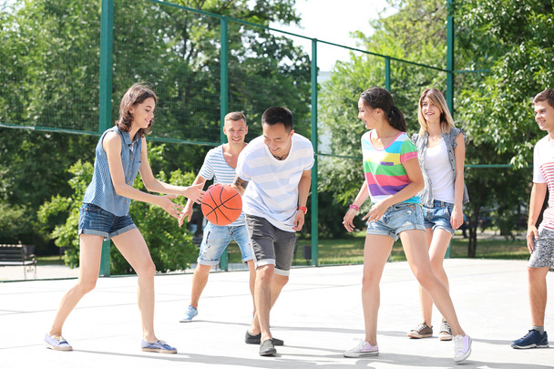 Teenagers playing basketball outdoors - Foto, afbeelding