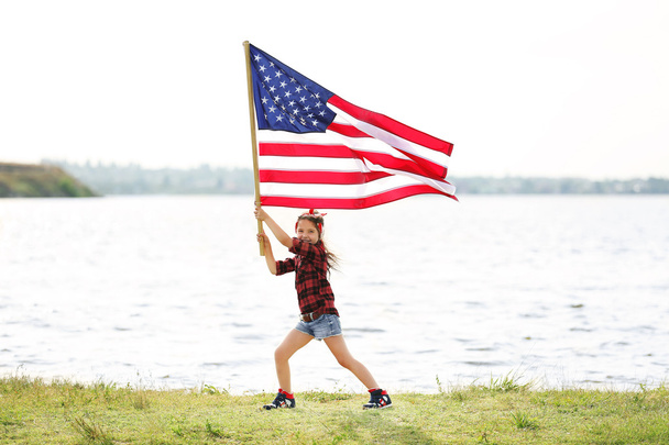 Small girl holding American flag - 写真・画像