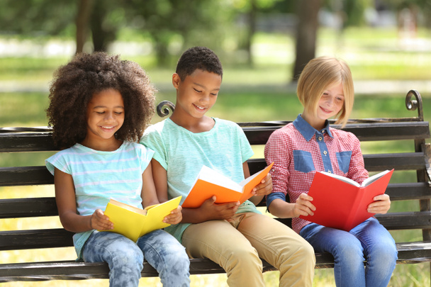 Cute kids reading books on bench - Zdjęcie, obraz