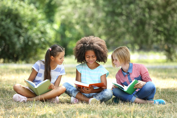 Cute kids reading books on green grass - Photo, image