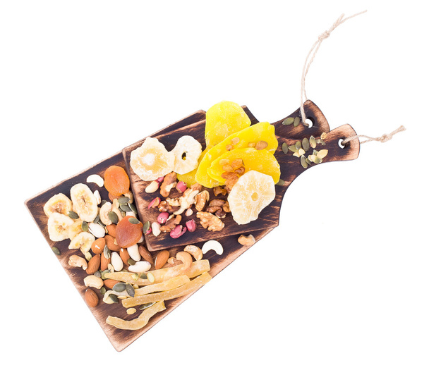 Mix of nuts and dry fruit on a wooden board - Foto, afbeelding
