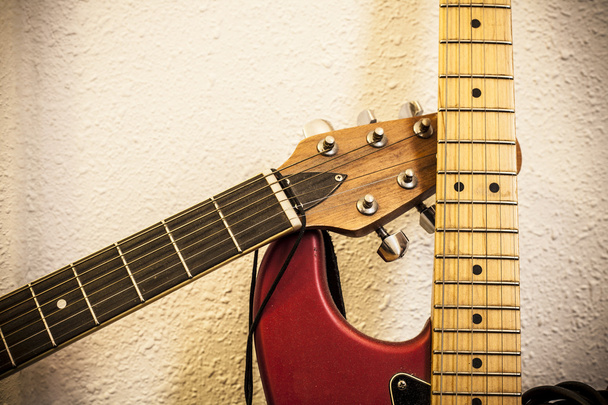 Fecho de dois pescoços de guitarra sobre fundo da parede
 - Foto, Imagem