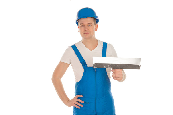 builder in blue uniform with putty knife - Φωτογραφία, εικόνα