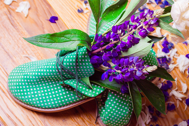 Sapatos verdes engraçados com flores. textura de madeira
 - Foto, Imagem