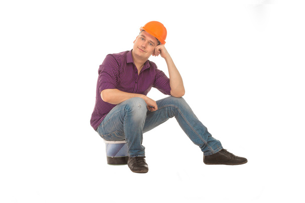 Man construction worket sits on a bucket  - Φωτογραφία, εικόνα