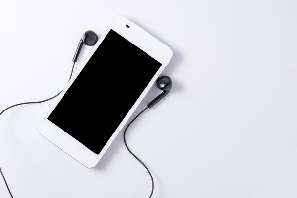 Mobile phone with headphone on white  - Foto, Imagen