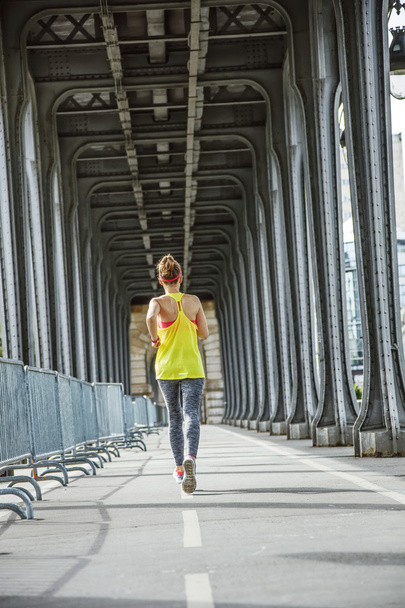 active woman running on Pont de Bir-Hakeim bridge in Paris - Фото, изображение
