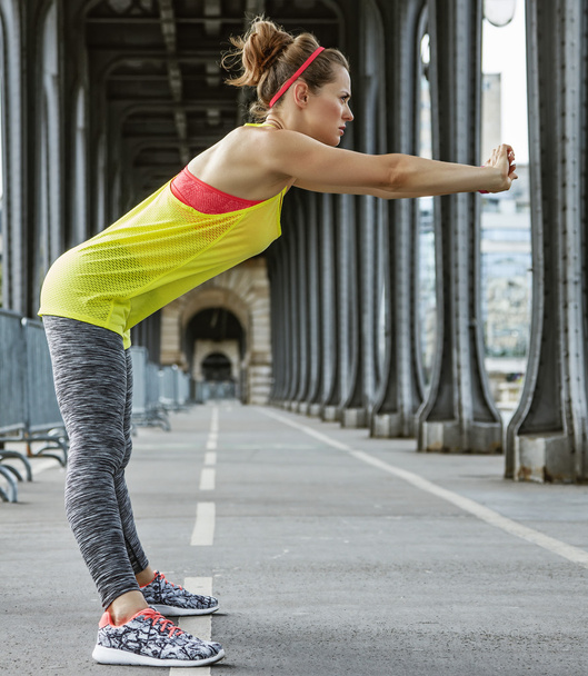 woman jogger stretching on Pont de Bir-Hakeim bridge in Paris - Photo, Image
