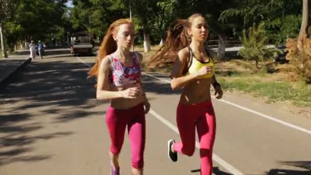 Sportos barátnők kocogás együtt szabadtéri parkban - Felvétel, videó