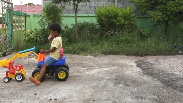 Söpö pieni poika ratsastaa traktorin lelu auto
 - Materiaali, video