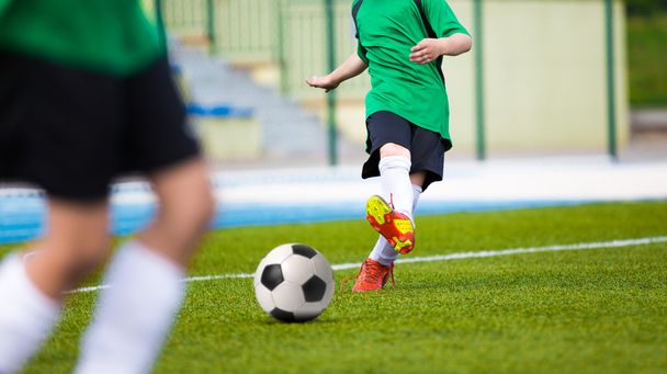 Football soccer kick. Young player kicking soccer ball - Zdjęcie, obraz
