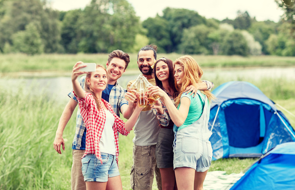 happy friends taking selfie by smartphone at camp - Fotografie, Obrázek