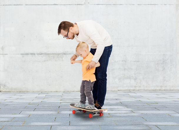 happy father and little son on skateboard - Φωτογραφία, εικόνα