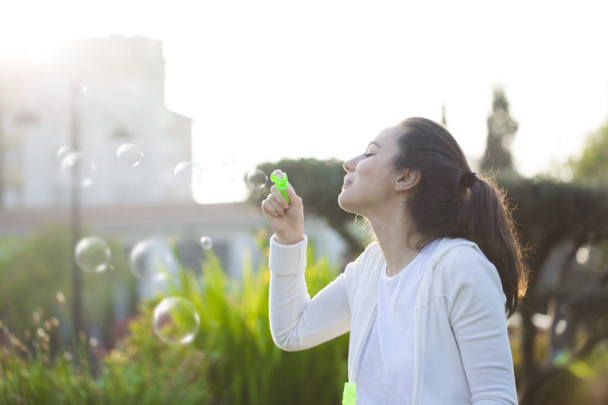 Young woman blowing bubbles  - Zdjęcie, obraz