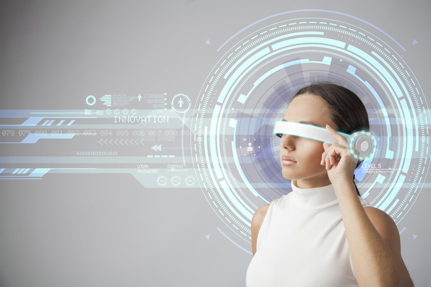 Young woman with futuristic smart glasses over gray background - Foto, Bild