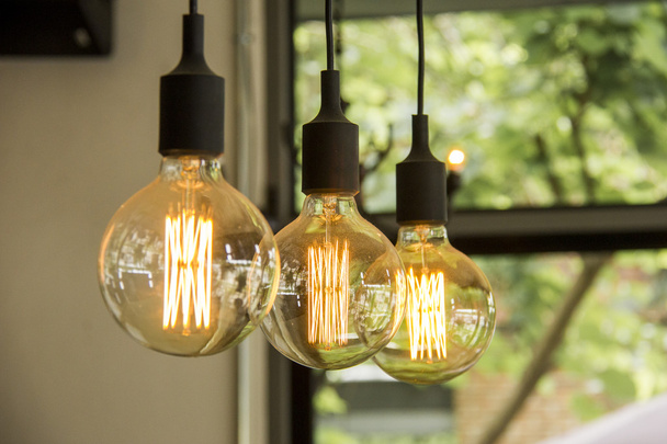 Glowing retro light bulbs hanging from ceiling - Photo, Image