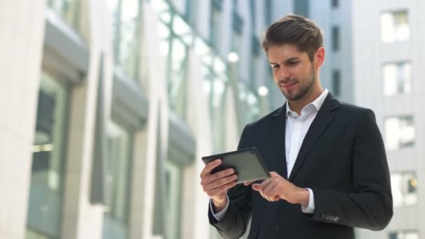 Hombre de negocios guapo leer noticias en Tablet Computer, espacio público urbano calle
 - Imágenes, Vídeo
