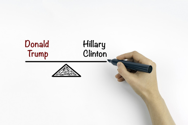 Ruka se značkou psaní Hillary Clintonová a Donald Trump balan - Fotografie, Obrázek