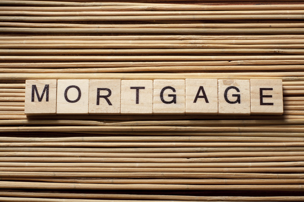 MORTGAGE word written on wood block at wooden background - Foto, Imagen