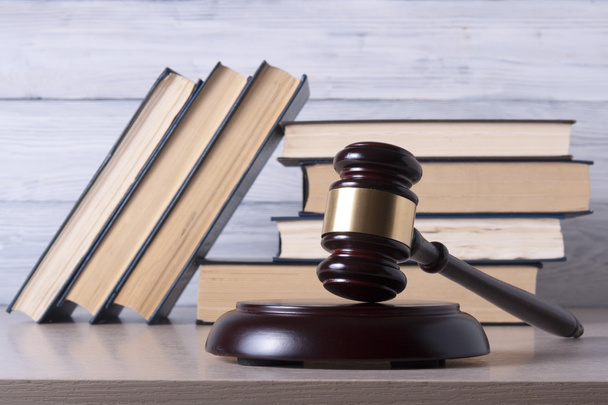 Концепція права - Книга з дерев'яними суддями, подана на столі в залі суду або виконавчій службі
. - Фото, зображення