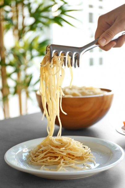 Female hand putting pasta - Φωτογραφία, εικόνα