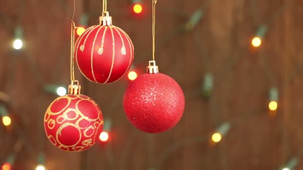 Rode kerstballen opknoping op snaren. Het opvlammen van een achtergrond wazig garland - Video