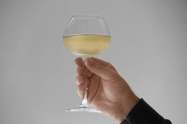 Hand with glass of white wine - Foto, afbeelding