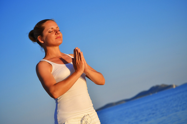 Mladá žena během jógy meditace na pláži - Fotografie, Obrázek