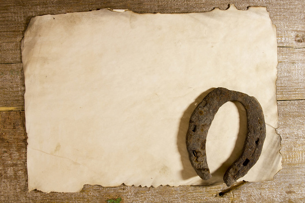 Vieux fer à cheval et une feuille de papier
 - Photo, image