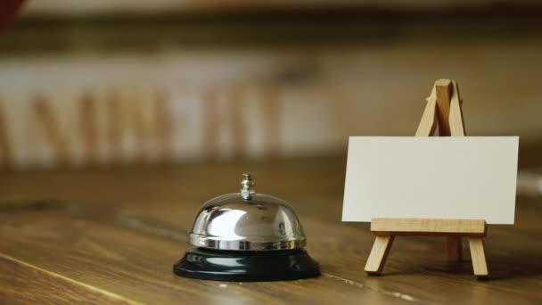 The visitor or customer calls table bell. Nearby stand with blank business card for your titles or labels - Metraje, vídeo