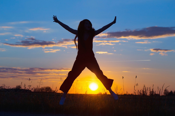 Молоді жінки радісно стрибають на заході сонця
 - Фото, зображення