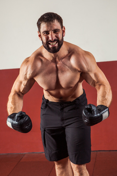強力な攻撃的なボクサーは、彼の筋肉を見せています。. - 写真・画像