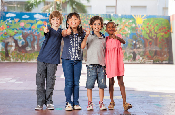 Elementary multi ethnic class children embracing happy at school - Photo, Image