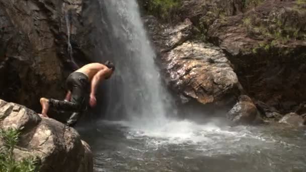 男が泡滝の近く川プールにジャンプします。 - 映像、動画