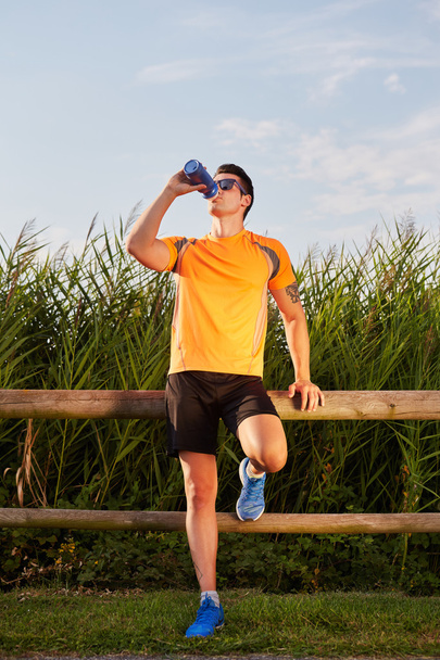 your runner drinking water by tin - Photo, image