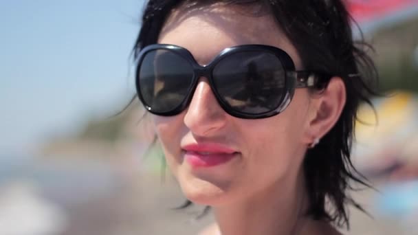 Εσωτερικη πορτρέτο του όμορφη νεαρή γυναίκα με γυαλιά ηλίου σε τροπική παραλία - Πλάνα, βίντεο