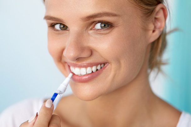 Healthy White Teeth. Beautiful Smiling Woman Using Whitening Pen - Φωτογραφία, εικόνα