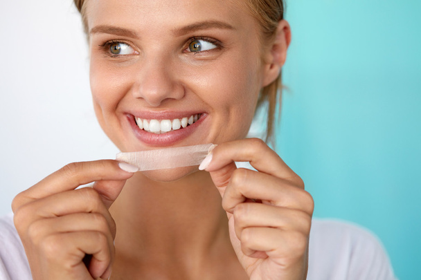 Woman With Healthy White Teeth Using Teeth Whitening Strip - Foto, Imagen