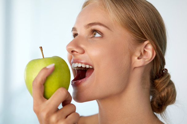 Γυναίκα μήλο διατροφικές. Όμορφο κορίτσι με λευκά δόντια, δάγκωμα Μήλου - Φωτογραφία, εικόνα