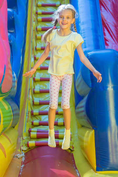 glückliches Mädchen springt auf einem aufblasbaren Trampolin - Foto, Bild