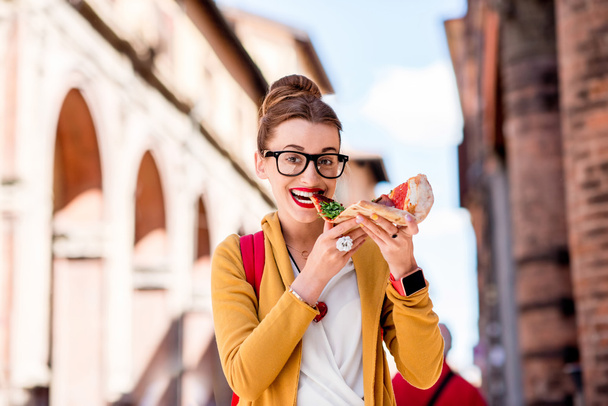 Student met pizza in de buurt van de Universiteit van Bologna stad - Foto, afbeelding