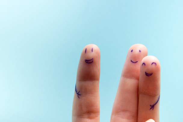 drei lächelnde Finger, die sehr glücklich sind, Freunde zu sein. Freundschaft Teamwork-Konzept auf blauem Hintergrund mit Kopierfläche für Anzeigentext. - Foto, Bild