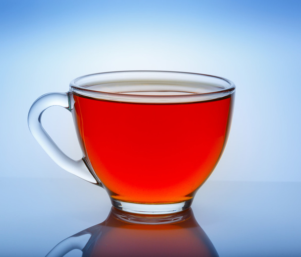 Krásný šálek čaje s odrazem na modrém pozadí - Fotografie, Obrázek