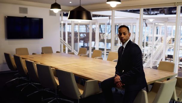 businessman sitting on board room table  - Foto, Bild