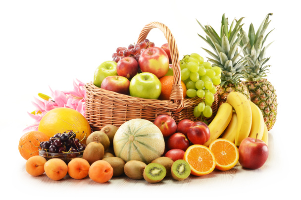 Samenstelling met diverse vruchten in rieten mandje - Foto, afbeelding